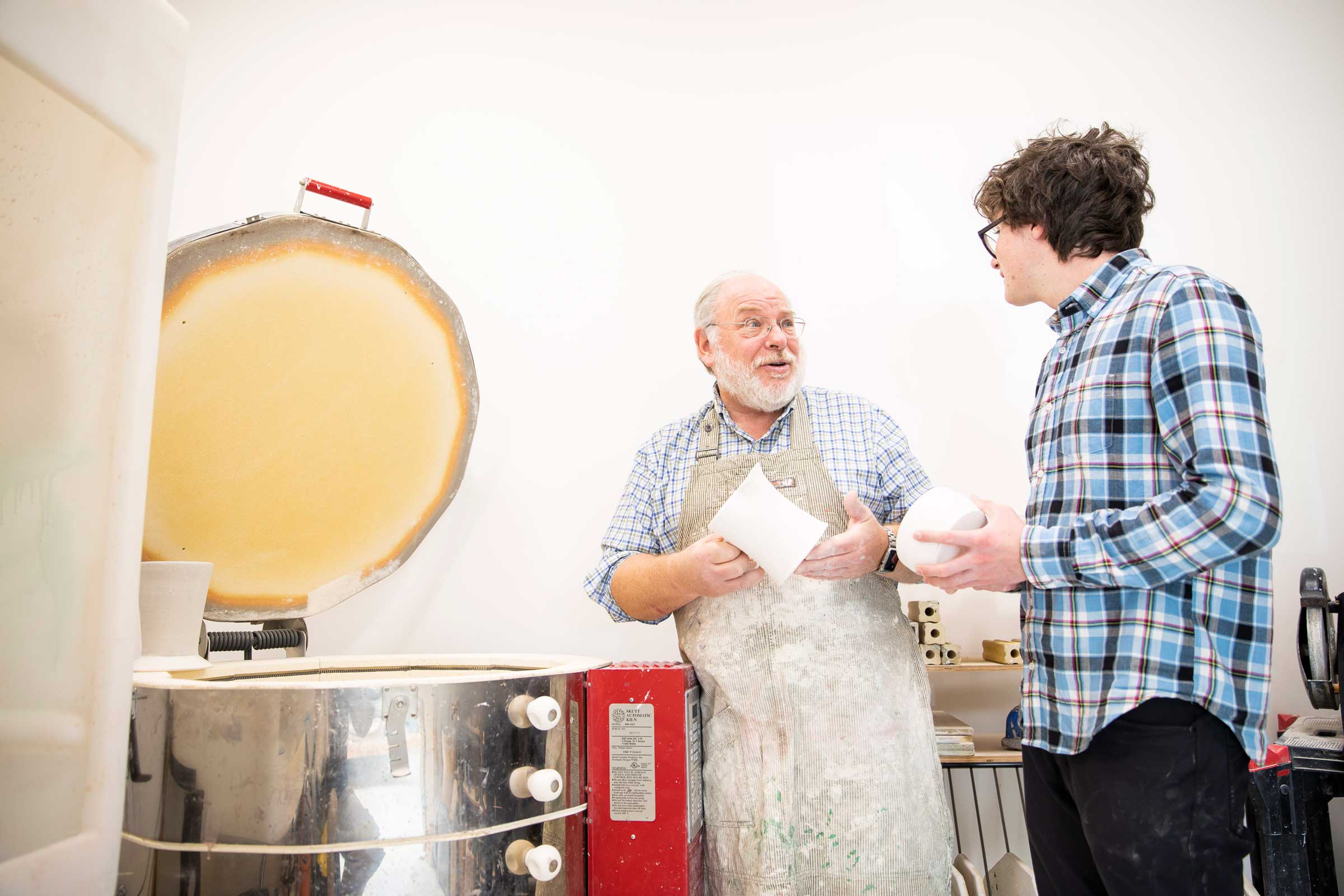 Teaching students to use the kiln in the Ceramics studio at Forman.